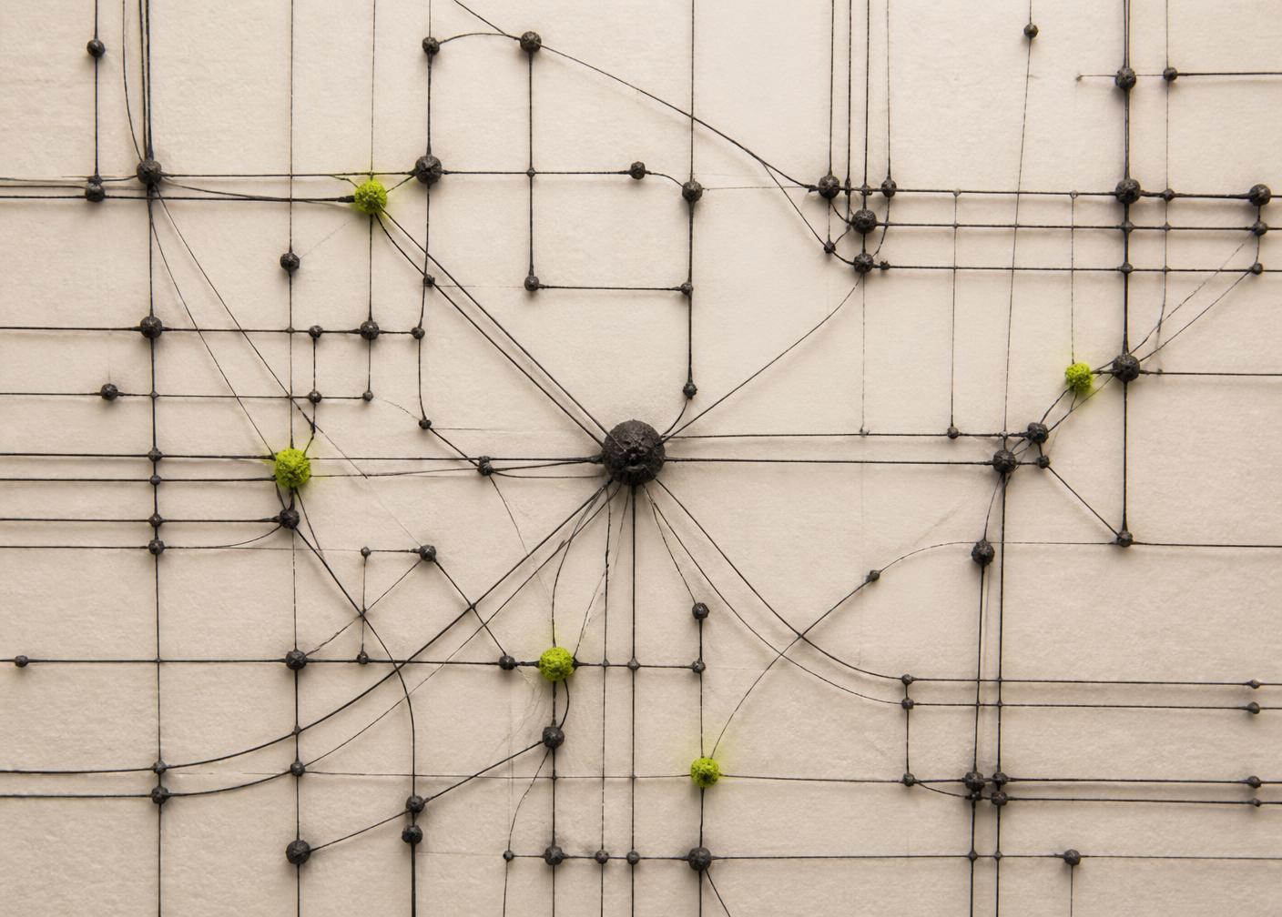 An abstract network of dark wires and nodes pinned to ivory paper with a few lime highlights